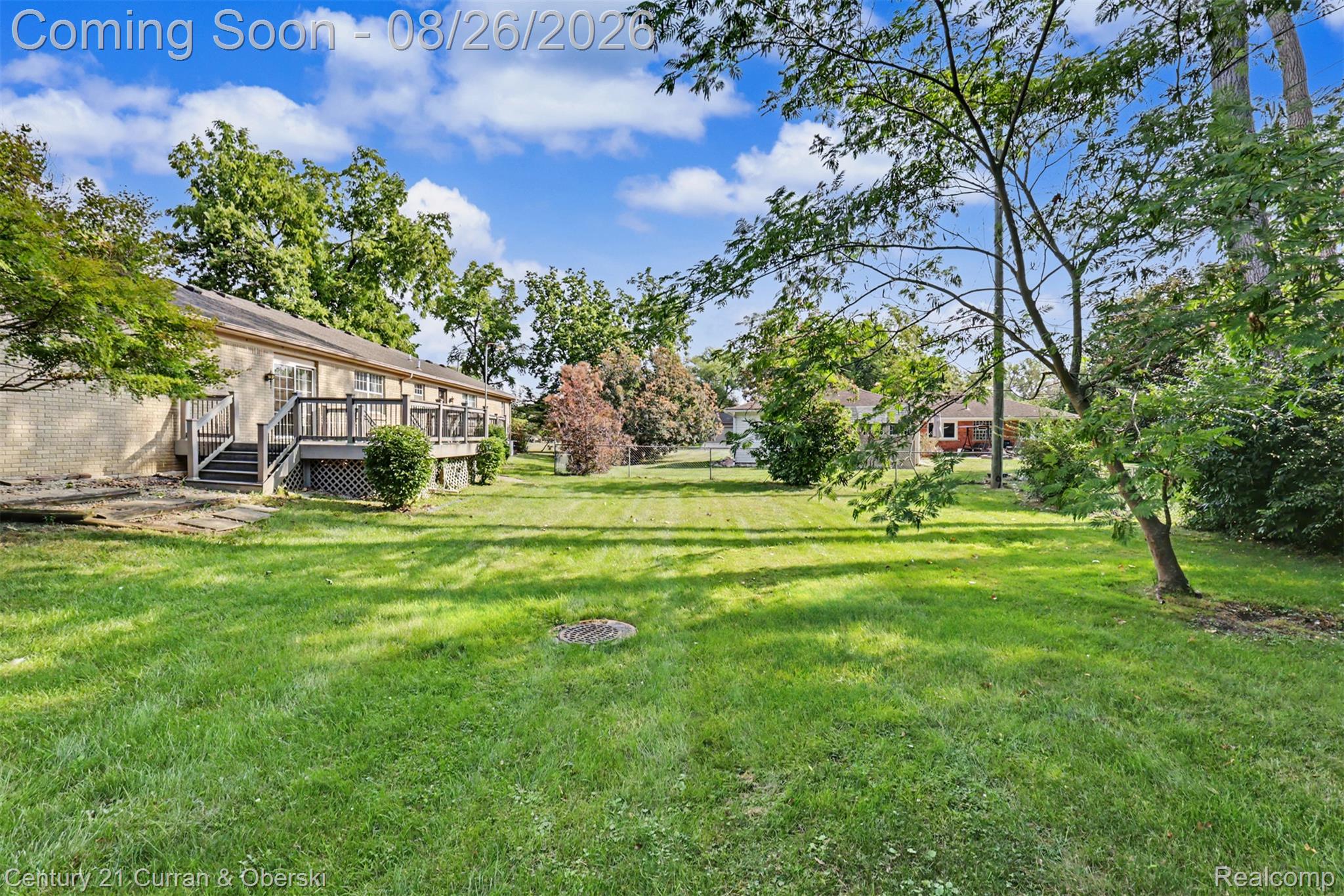 18227 Meridian Road Grosse Ile, MI 48138 - Photo 21 of 23 Expansive backyard featuring a manicured lawn, mature trees, and a multi-level wood deck
