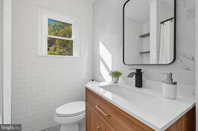a bathroom with a toilet sink and mirror