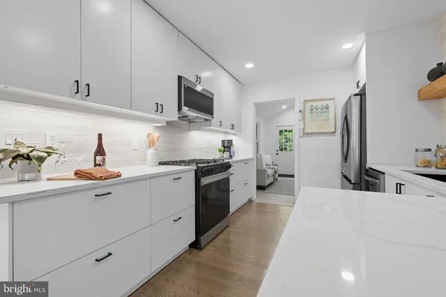 a kitchen with stainless steel appliances a sink stove and cabinets