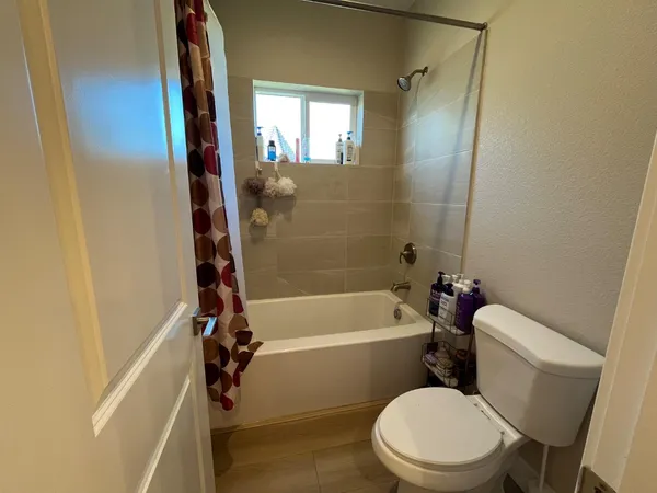a white toilet and tub sitting next to a bathroom sink