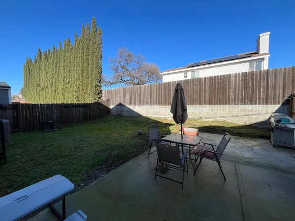 a backyard of a house with table and chairs