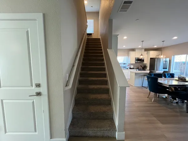 a view of a dining room with wooden floor and stairs