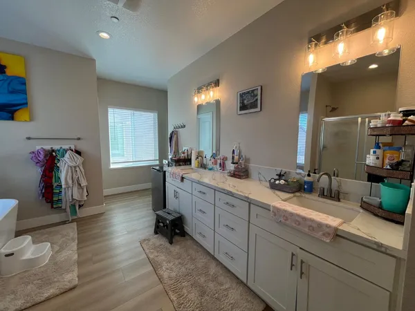 a bathroom with double vanity sinks a vanity and a mirror