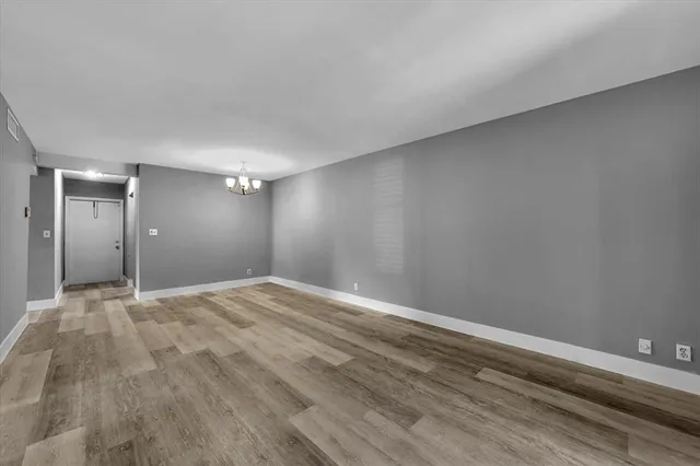 a view of an empty room and wooden floor