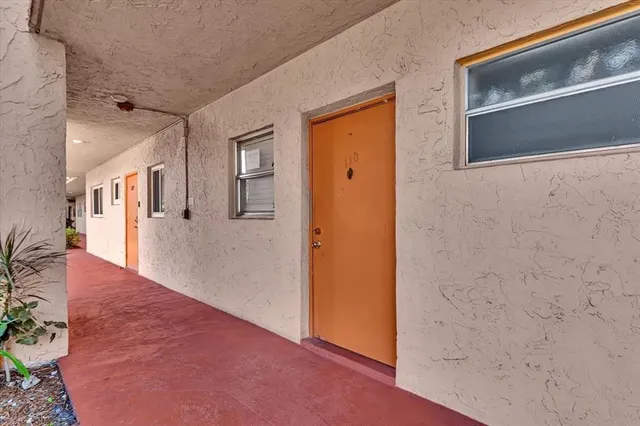 a view of a hallway with wooden floor and cabinet