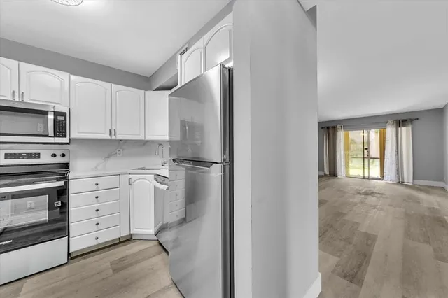 a kitchen with white cabinets and stainless steel appliances