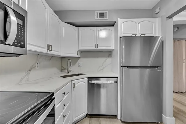 a white refrigerator freezer and a wooden cabinets