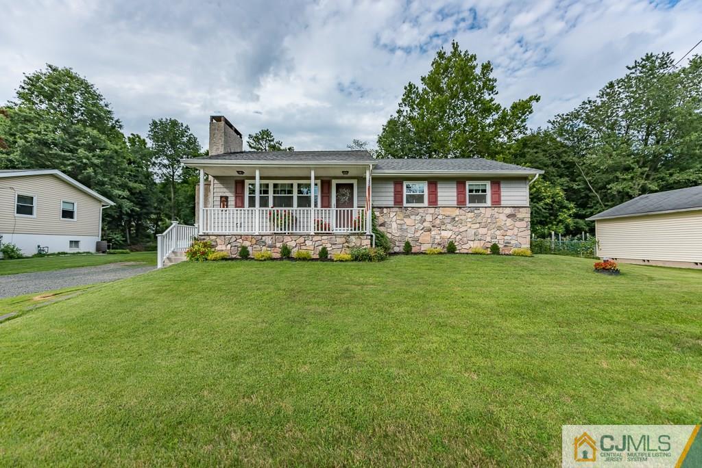 a front view of a house with a garden and trees