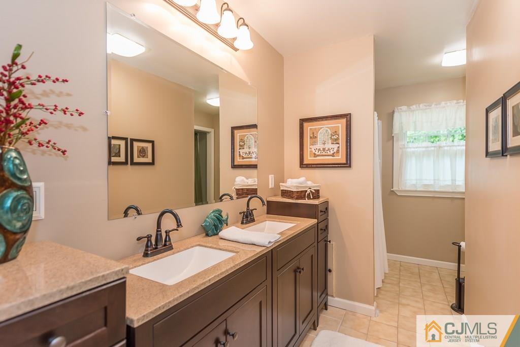 21 Mill Street Stockton, NJ 08559 - Photo 11 of 25 a bathroom with double vanity sinks a mirror and a shower