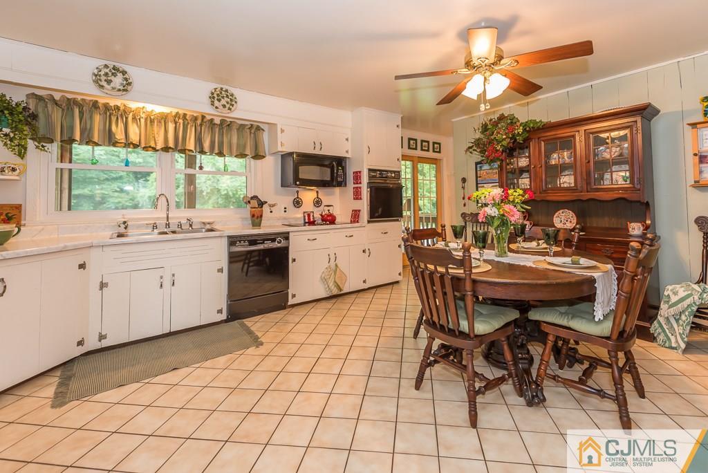 21 Mill Street Stockton, NJ 08559 - Photo 7 of 25 a kitchen with stainless steel appliances a sink a stove a dining table and chairs