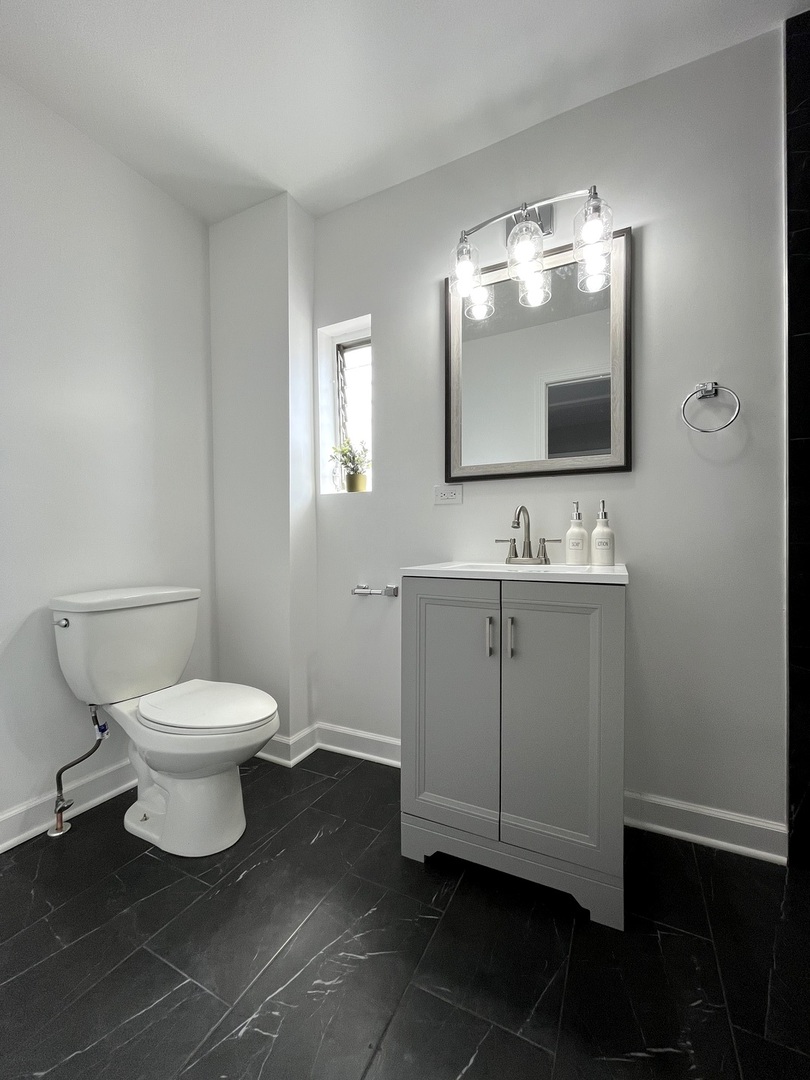 5146 South Homan Avenue Chicago, IL 60632 - Photo 14 of 20 a bathroom with a toilet sink and mirror