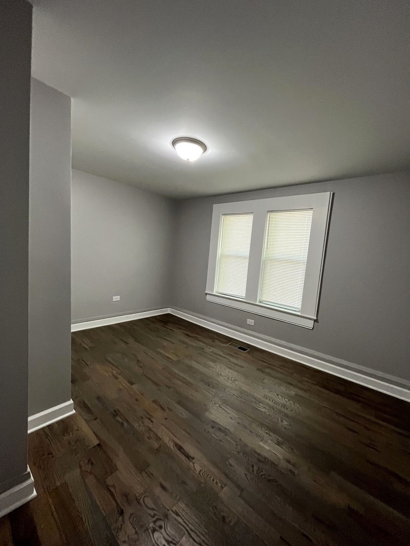 5146 South Homan Avenue Chicago, IL 60632 - Photo 17 of 20 an empty room with wooden floor and windows