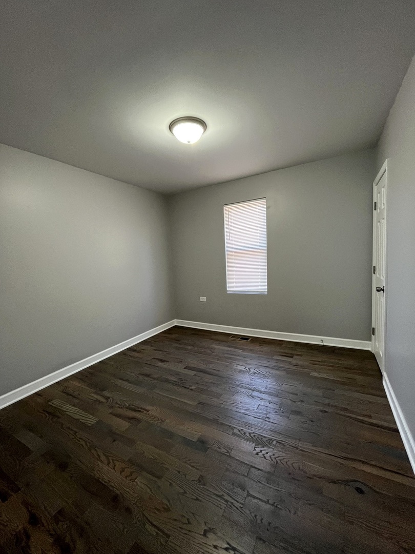 5146 South Homan Avenue Chicago, IL 60632 - Photo 18 of 20 an empty room with wooden floor and windows