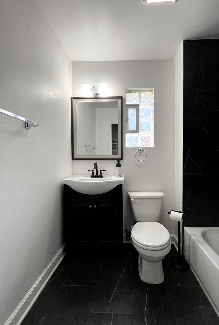 5146 South Homan Avenue Chicago, IL 60632 - Photo 10 of 20 a bathroom with a toilet sink and mirror