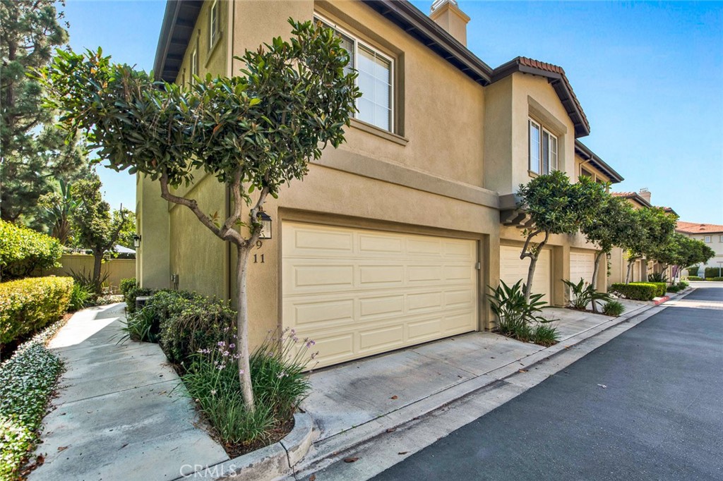 9 Darlington Irvine, CA 92620 - Photo 2 of 21 a small white house with a flower garden and potted plants