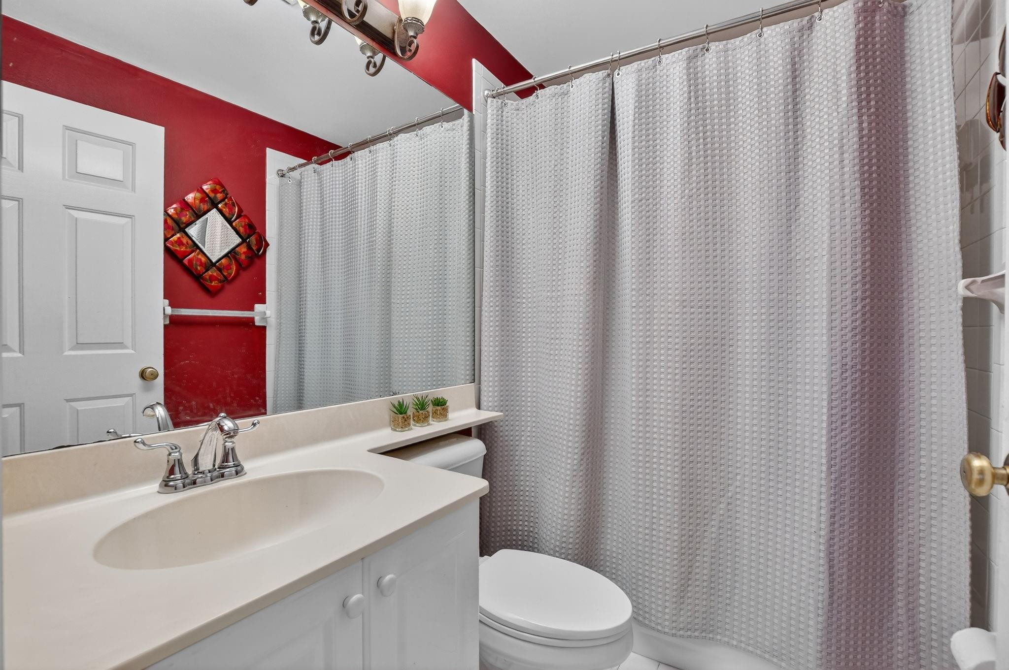 12614 Tiboli Chase Court, Unit 1 Boca Raton, FL 33496 - Photo 25 of 62 a bathroom with a sink a toilet and curtain