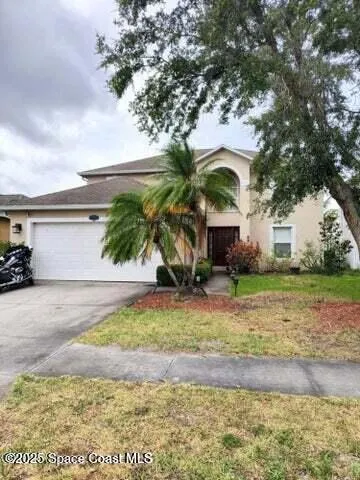 a front view of house with garden space and trees