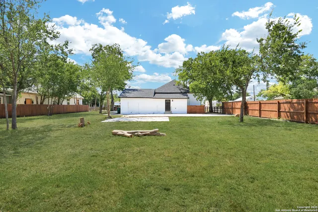 a view of a house with a big yard and a large tree