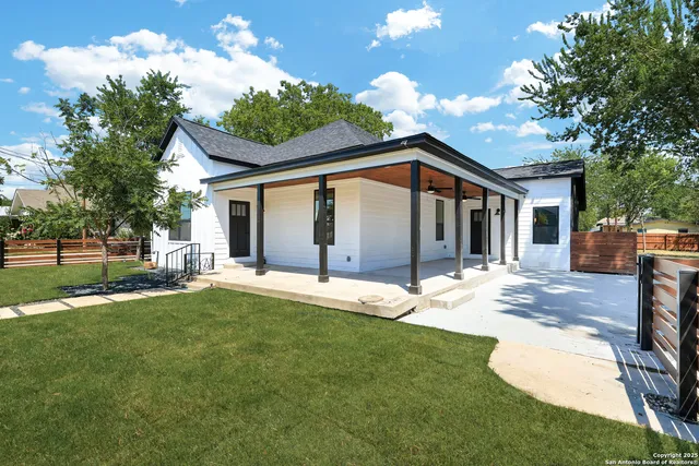 a view of a house with a backyard and a tree