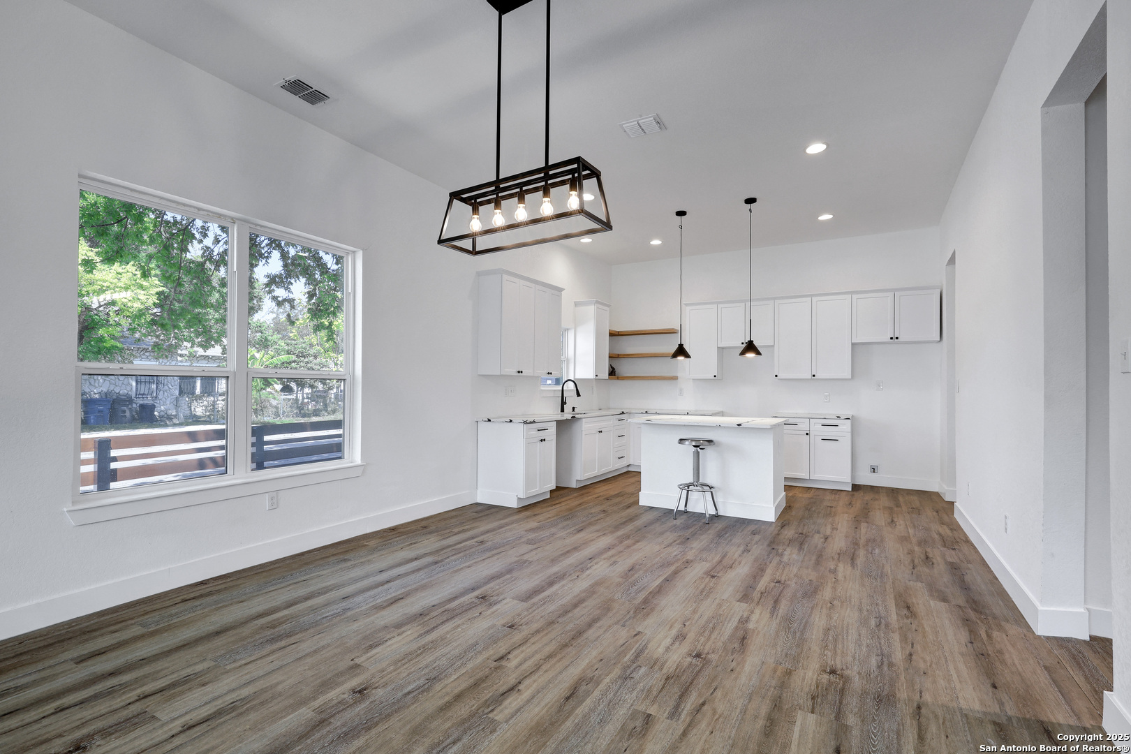 2425 Monterey Street San Antonio, TX 78207 - Photo 10 of 35 a kitchen with stainless steel appliances granite countertop a stove a sink a refrigerator and white cabinets with wooden floor