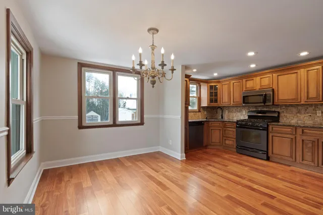 a kitchen with stainless steel appliances granite countertop a refrigerator stove top oven and sink