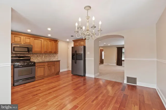 a view of a kitchen with granite countertop stainless steel appliances and wooden floor
