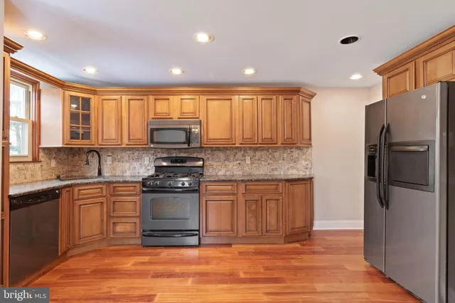 a kitchen with kitchen island granite countertop a stove top oven a sink and a refrigerator
