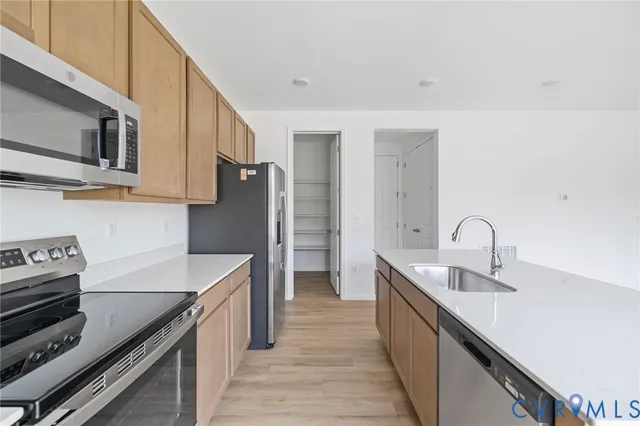 a kitchen with stainless steel appliances granite countertop a sink and a stove