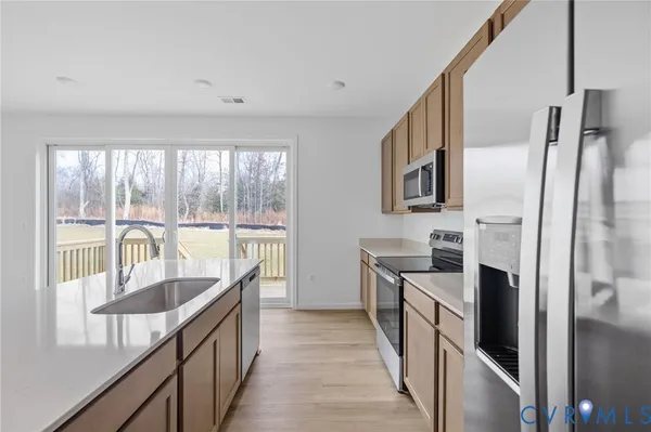 a kitchen with stainless steel appliances granite countertop a refrigerator a stove and a sink