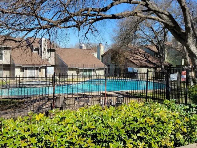 a view of an empty room with wooden floor and a fireplace
