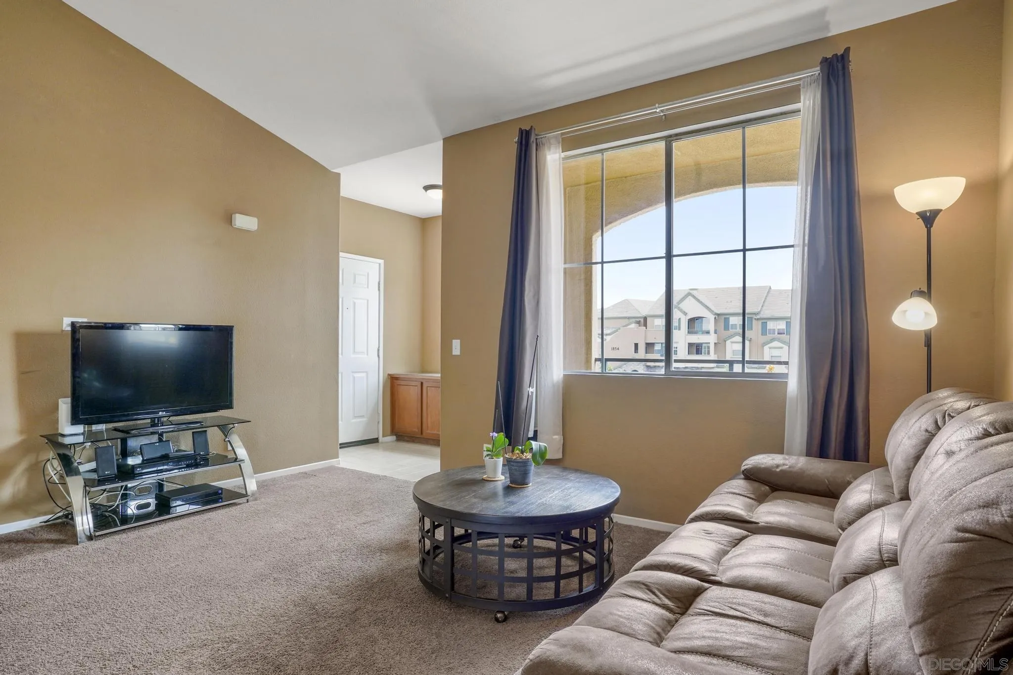 1853 Rue Bienville Place, Unit 833 Chula Vista, CA 91913 - Photo 7 of 23 a living room with furniture and a flat screen tv