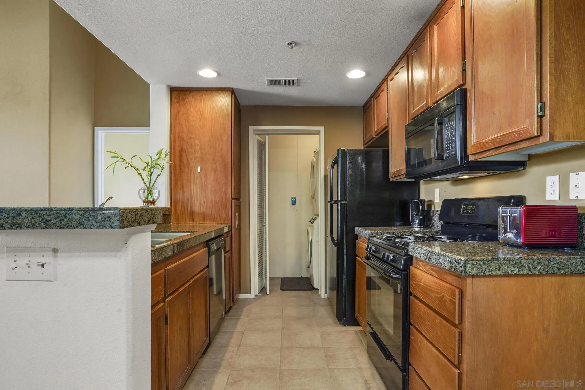 1853 Rue Bienville Place, Unit 833 Chula Vista, CA 91913 - Photo 10 of 23 a kitchen with stainless steel appliances granite countertop a refrigerator a stove and a sink