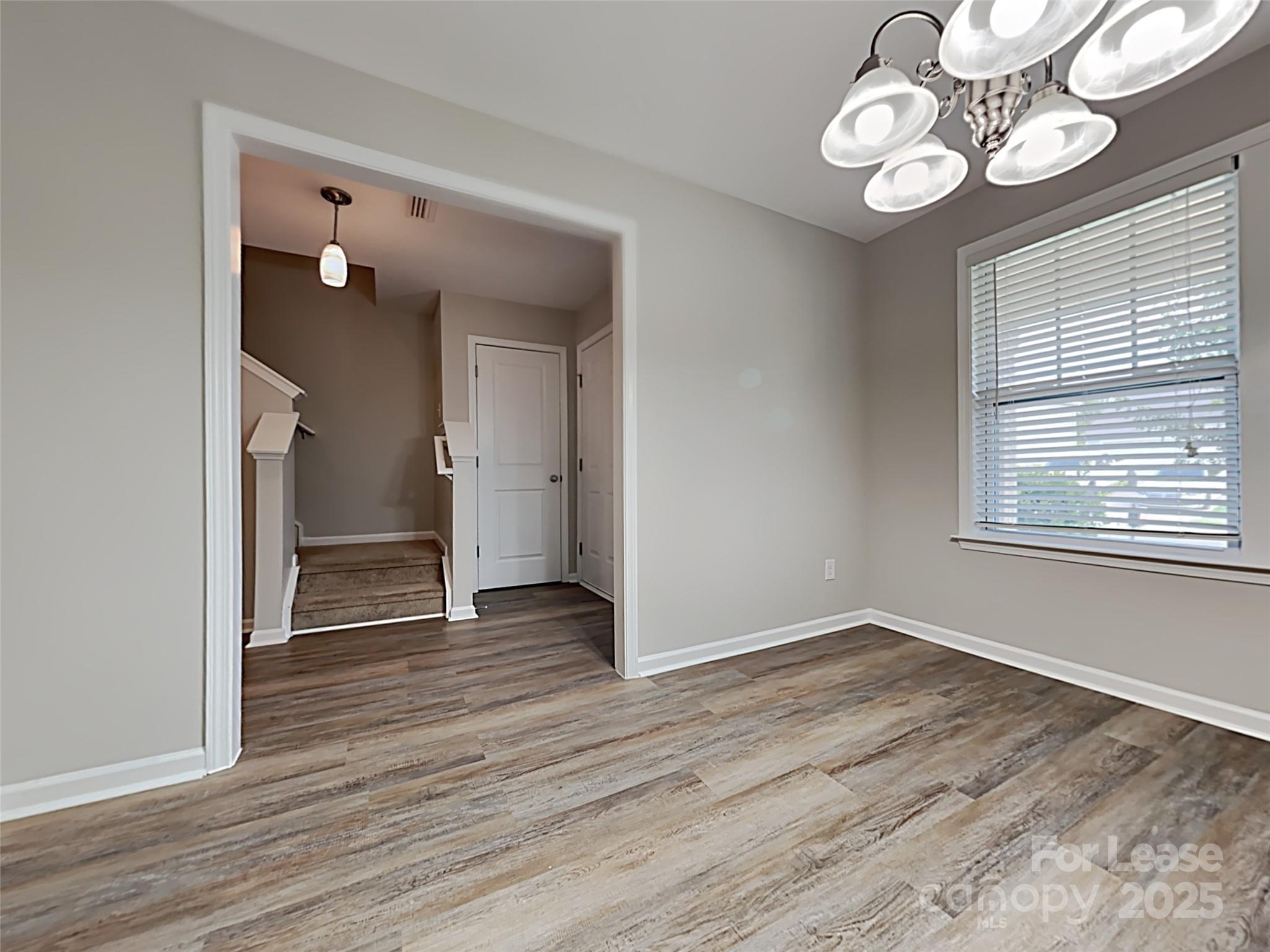 8188 Thornton Street Locust, NC 28097 - Photo 7 of 17 a view of an empty room with wooden floor and a window