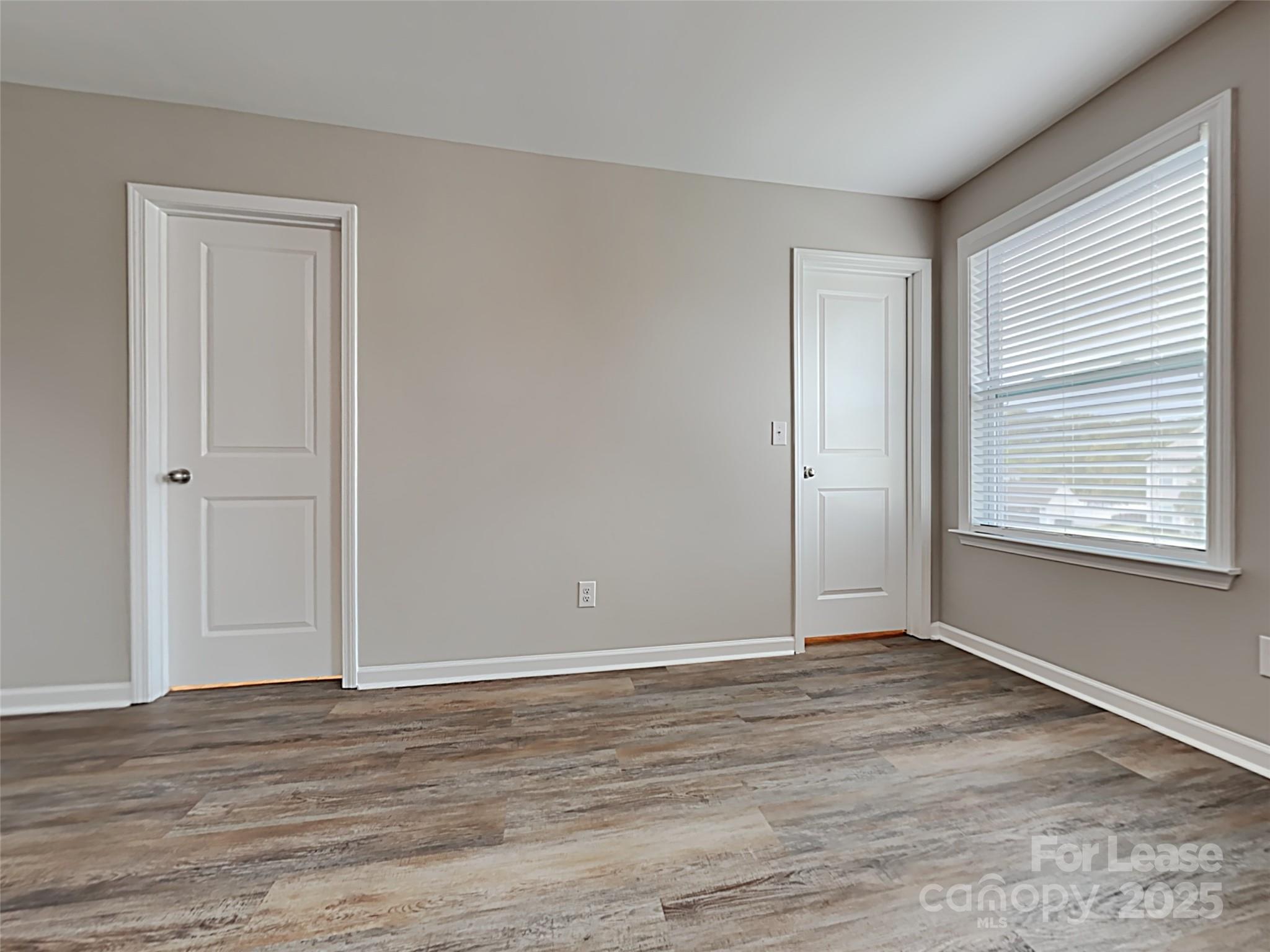 8188 Thornton Street Locust, NC 28097 - Photo 8 of 17 a view of an empty room with wooden floor and a window