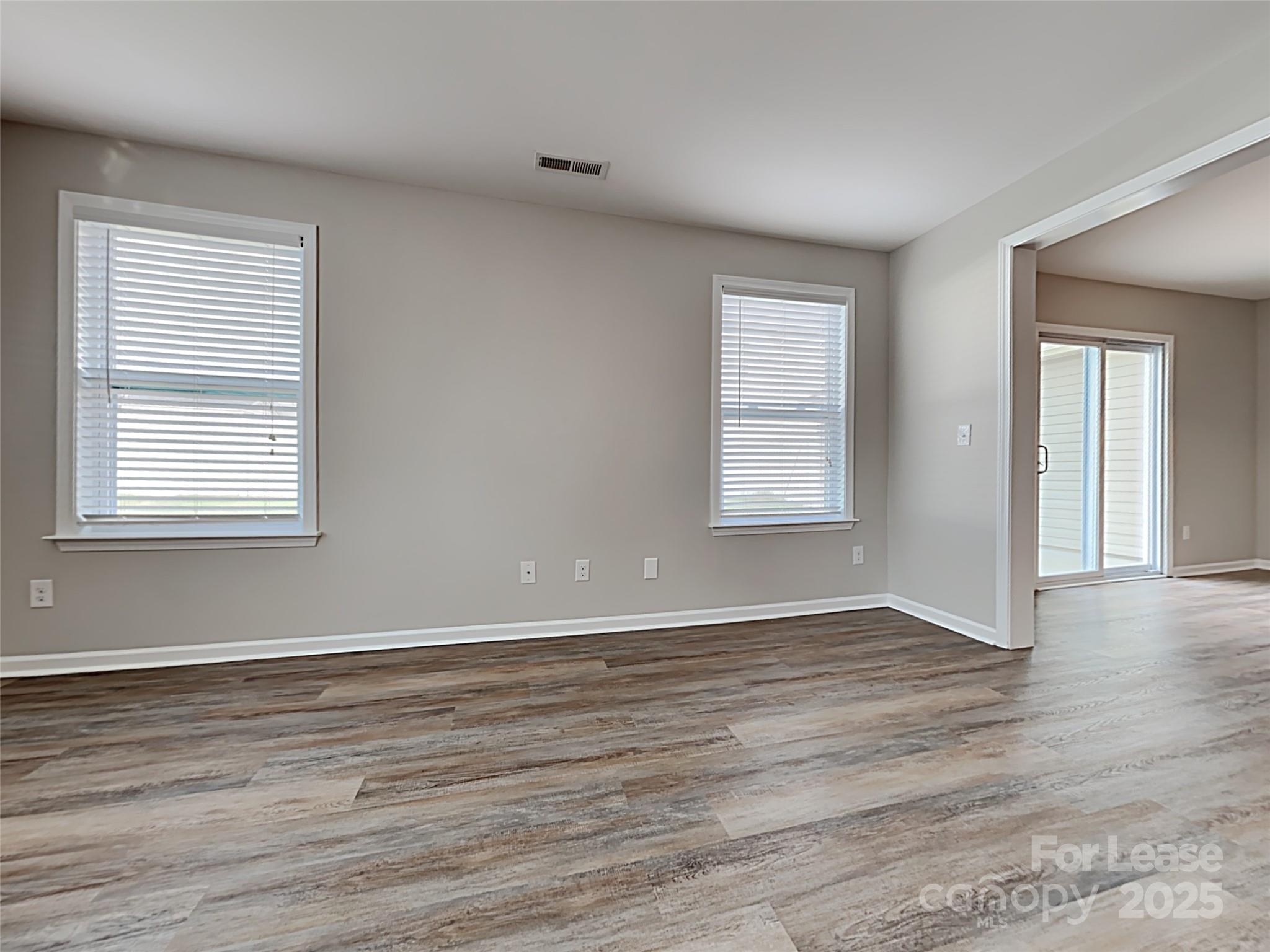 8188 Thornton Street Locust, NC 28097 - Photo 9 of 17 an empty room with wooden floor and windows
