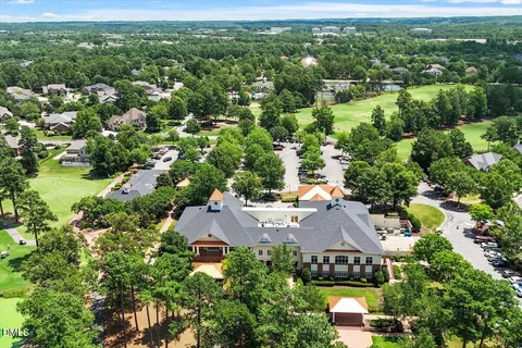 an aerial view of residential houses with outdoor space and trees