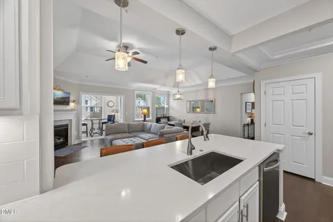 a kitchen with a sink a refrigerator and chairs