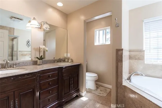 a bathroom with a granite countertop sink a toilet and a bathtub