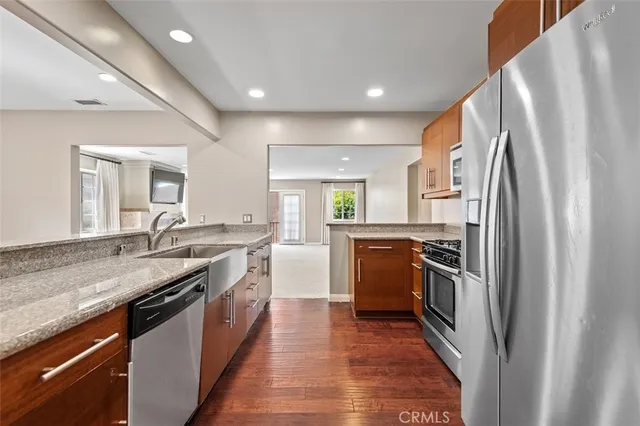 a kitchen with stainless steel appliances granite countertop a stove a sink and a refrigerator