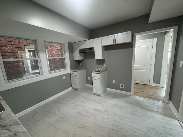 a view of a kitchen with refrigerator and window