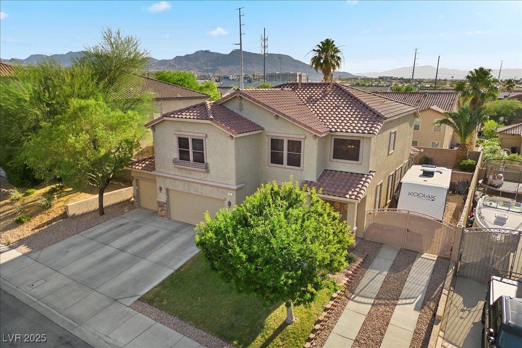 249 Cinnamon Ridge Way Henderson, NV 89015 - Photo 4 of 76 Mediterranean / spanish home with a gate, stucco siding, a tile roof, an attached garage, and a mountain view