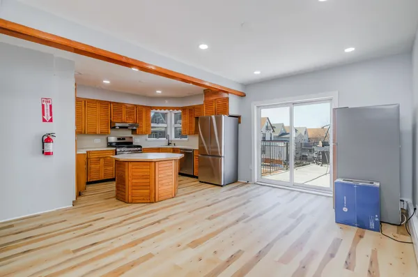 a kitchen with stainless steel appliances wooden floor and wooden cabinets