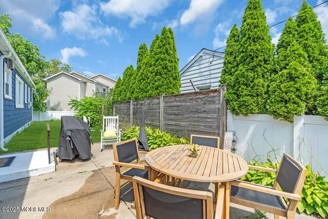 a view of a patio with table and chairs potted plants with wooden fence