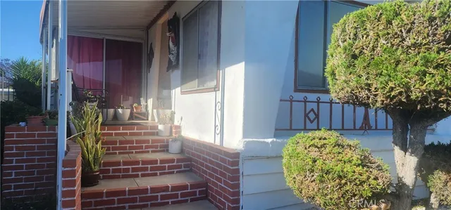 a view of a house with a large windows and flower plants