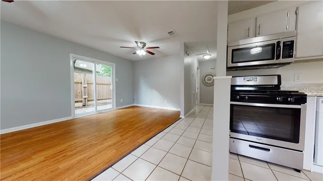 a kitchen with stainless steel appliances kitchen island granite countertop a stove and a microwave