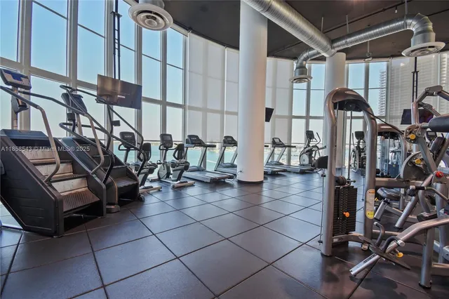 a living room with furniture pool table and wall paintings