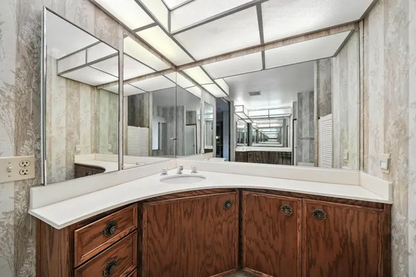 a spacious bathroom with a tub sink and mirror
