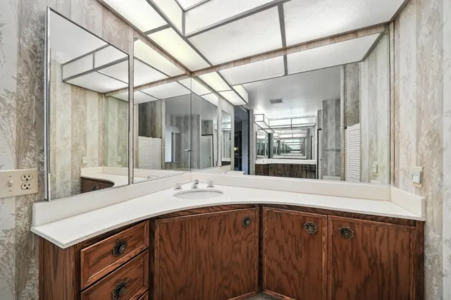 a spacious bathroom with a tub sink and mirror
