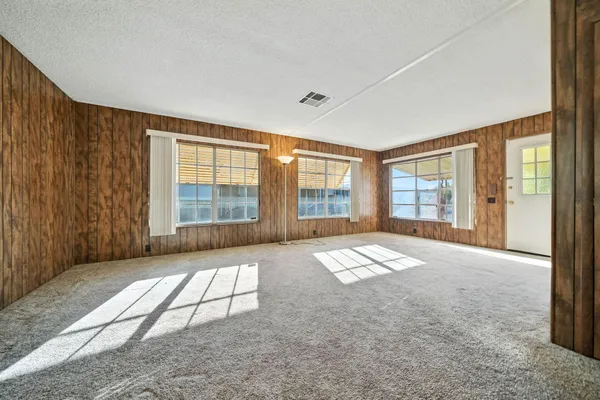 a view of a livingroom with wooden furniture and windows