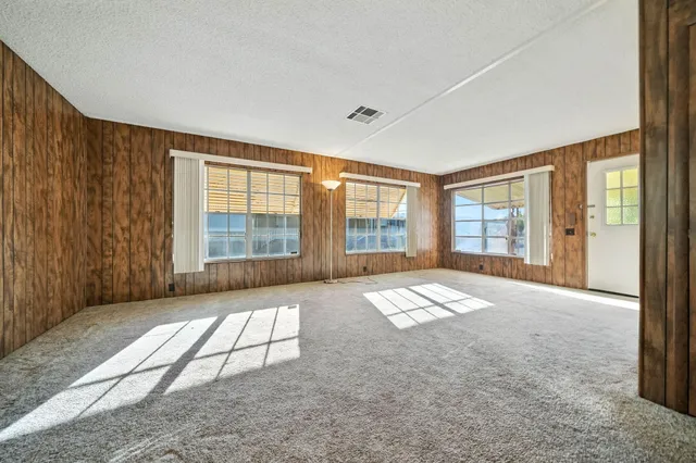 a view of a livingroom with wooden furniture and windows